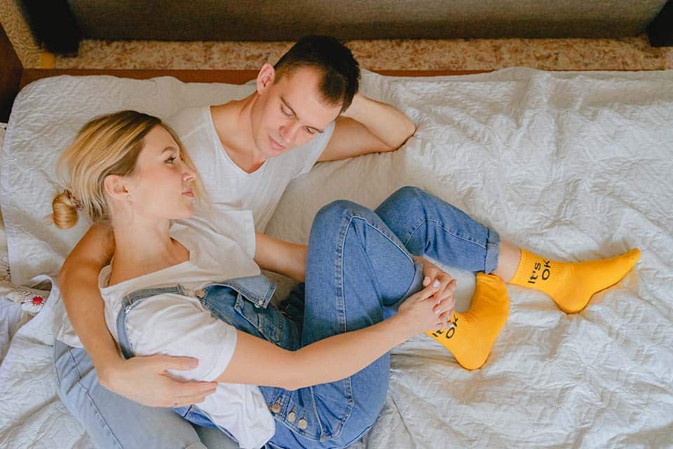 man and woman cuddling on bed